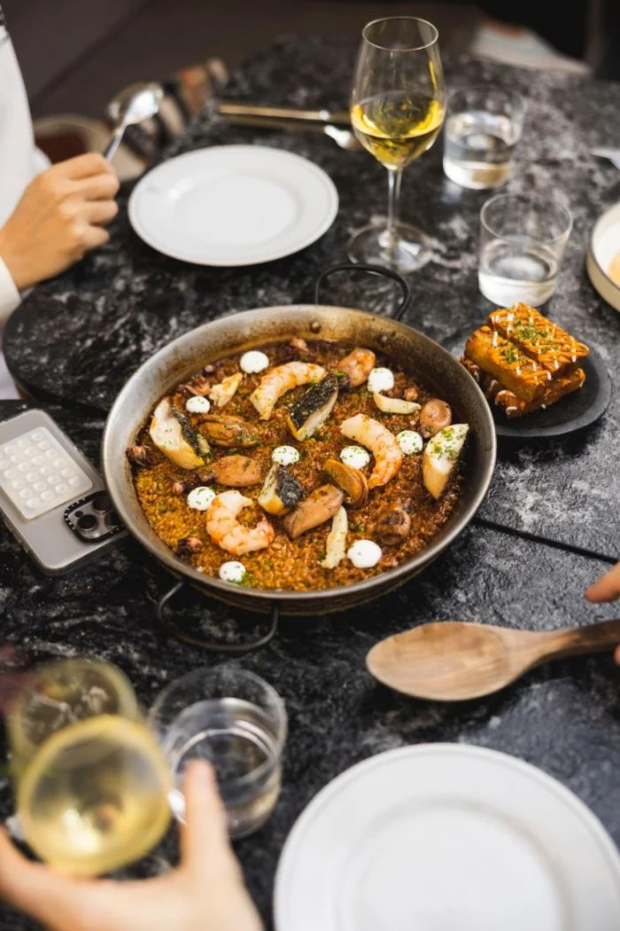 COSTA7070 celebra el Día de la Paella con fuegos encendidos frente al río y cuatro variedades imperdibles